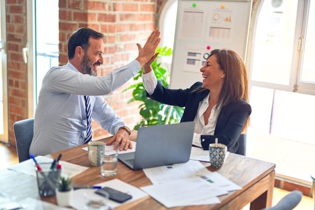 A business owner guiding a virtual assistant through an onboarding checklist on a laptop, ensuring a smooth integration into the workflow.
